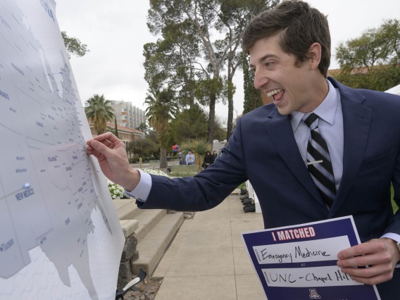 A University of Arizona College of Medicine – Tucson fourth-year medical student puts a pin in a map of the United States identifying where he matched for residency. 