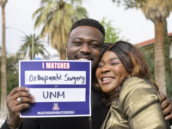 A fourth-year medical student from the University of Arizona College of Medicine – Tucson hugs his mom as he holds up a poster that says “I Matched.” 