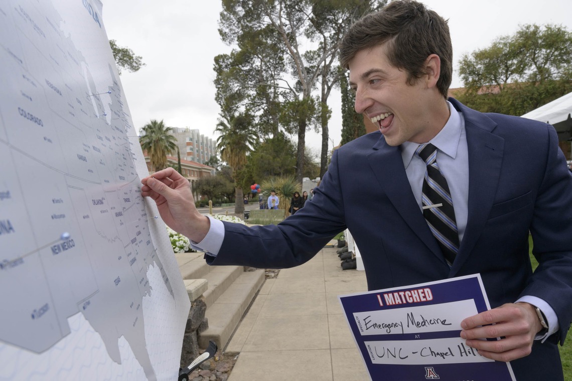 A University of Arizona College of Medicine – Tucson fourth-year medical student puts a pin in a map of the United States identifying where he matched for residency. 