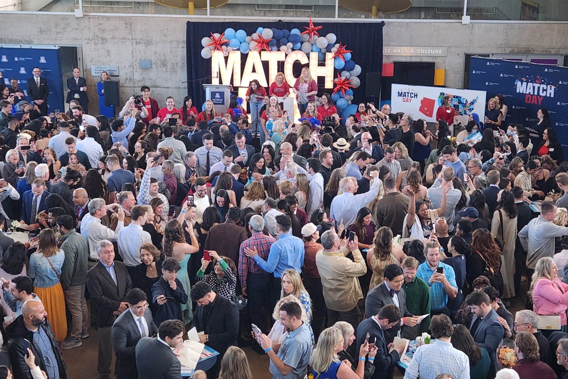 A large crowd of people watch perfomers on a stage at the University of Arizona College of Medicine – Phoenix Match Day celebration. 