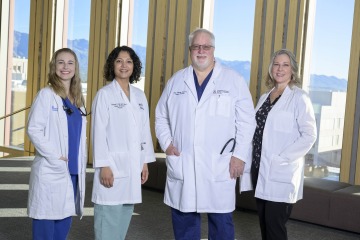 Four faculty members pose for a photo inside the Health Sciences Innovation Building. 