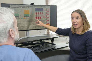 Gloria Coronado, PhD, points to a computer screen as she speaks with Karl Krupp, PhD, an assistant professor of public health practice in the Mel and Enid Zuckerman College of Public Health.